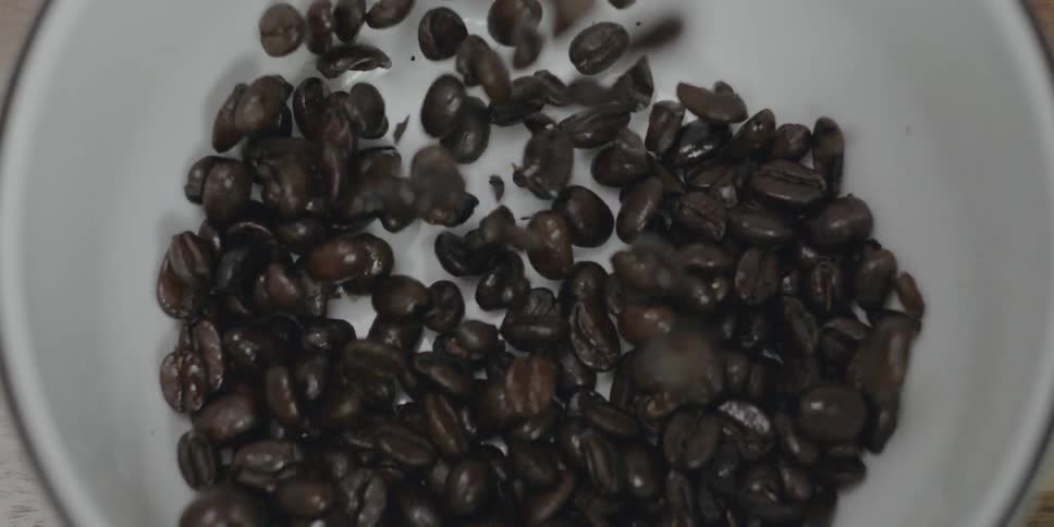 Coffee beans are falling into a container