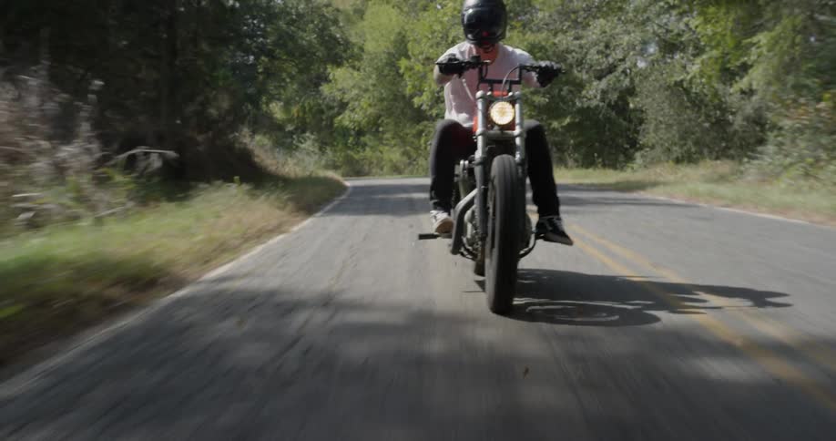 A motorcyclist rides on a rural road
