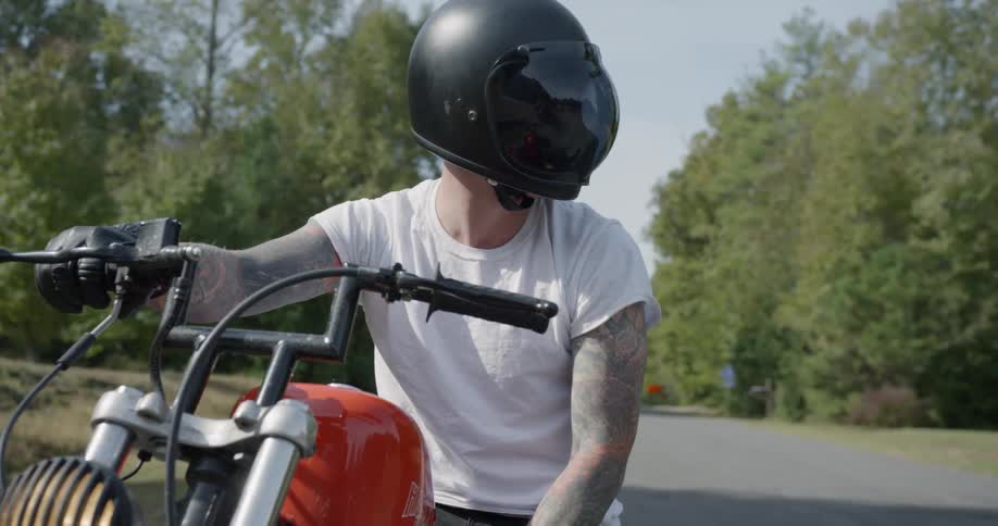 A motorcyclist is stopped on a rural road