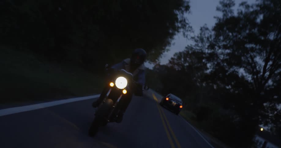 Person is riding motorcycle on highway at night