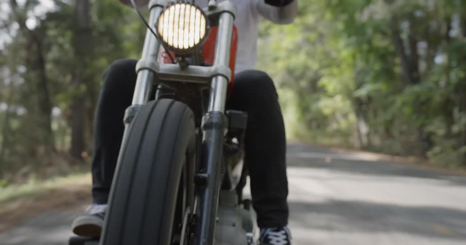 A man motorcycles on a rural road