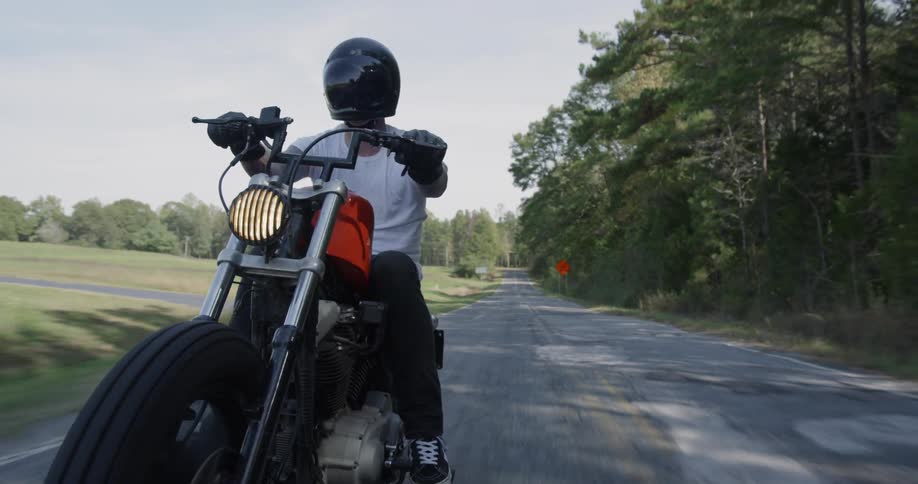 Man motorcycles on a rural road