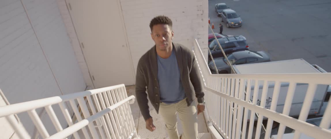 A man walks up outdoor stairs
