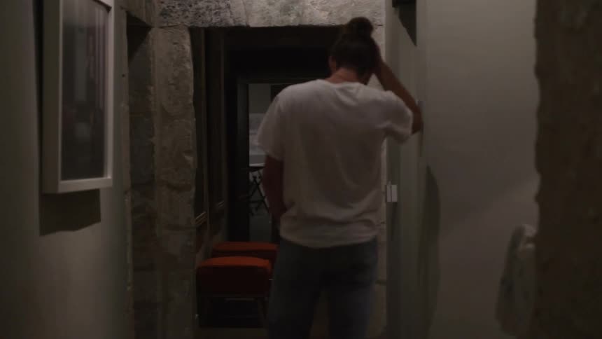 A woman pauses while walking in a hallway