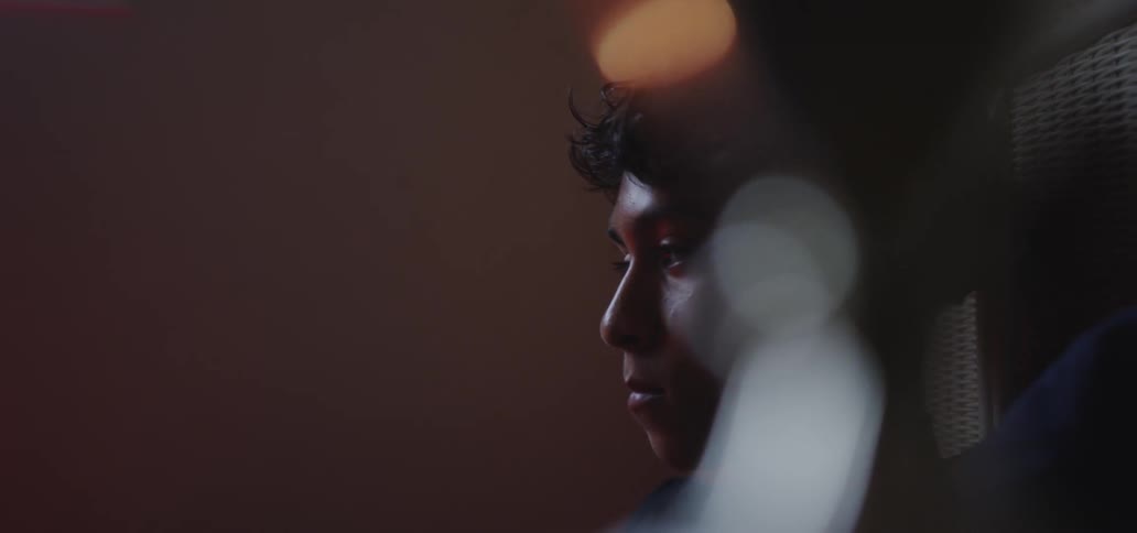 A teenager looks sad while sitting in bed