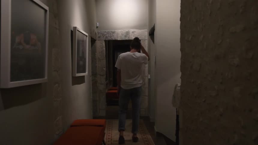 Man walks down dimly lit hallway