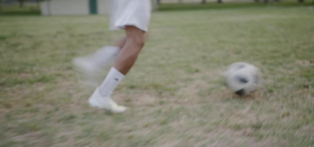Man kicks a soccer ball towards the net