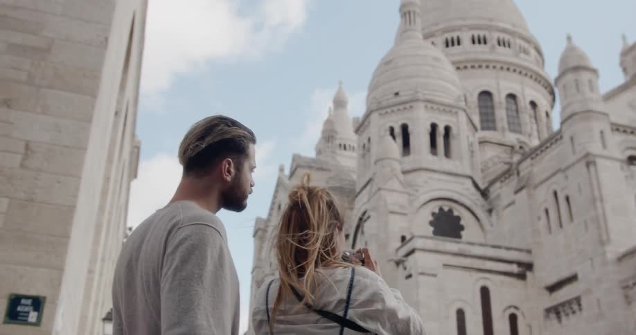 A man and woman photograph an ornate building