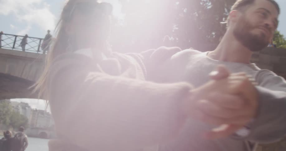A man and woman spin and dance outside