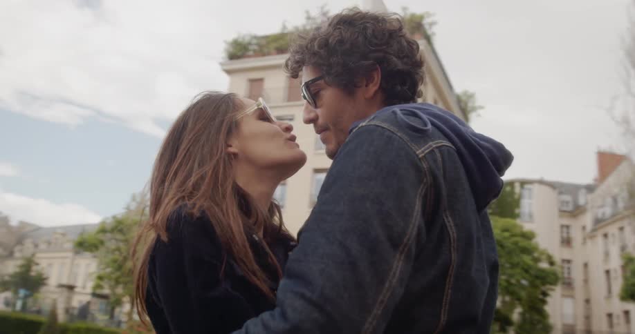 Man and woman kiss under the cloudy sky