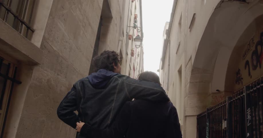 Man and woman walk between the buildings in a city