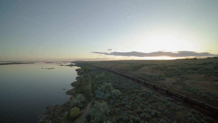 Flying parallel with a fast running oil train along a riverbank