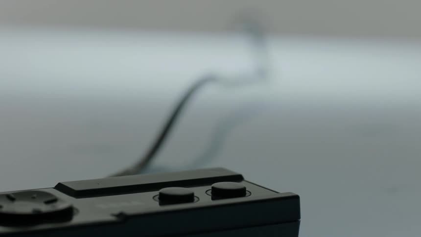 A sega video game controller is dragged across a table