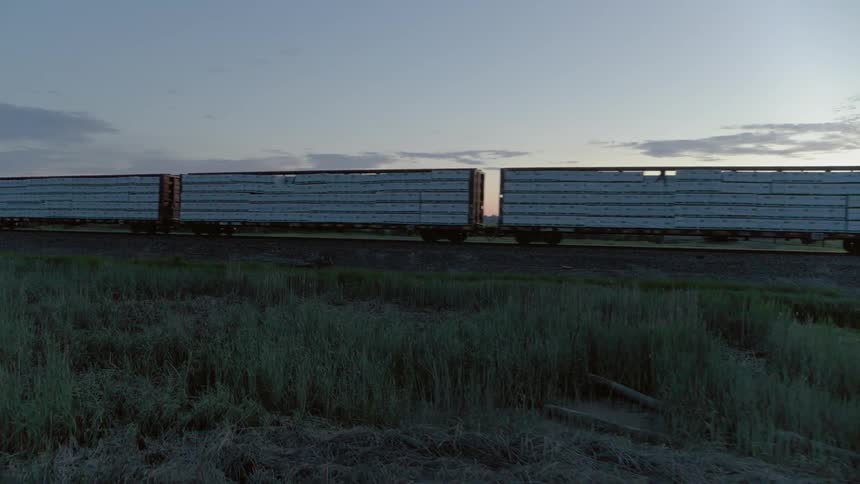 A short haul freight train travels down the tracks at twilight