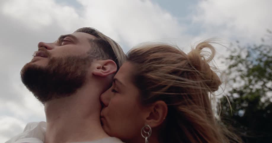 A man and woman embrace outside