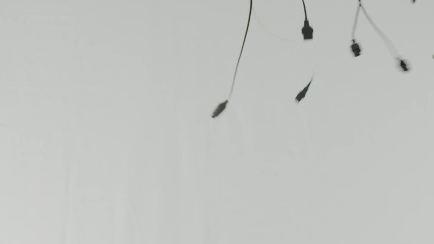 Cords dangle in a white room