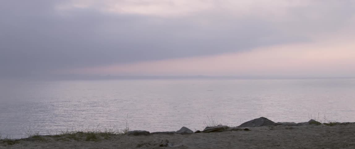 Lake ripples gently under the cloudy sky