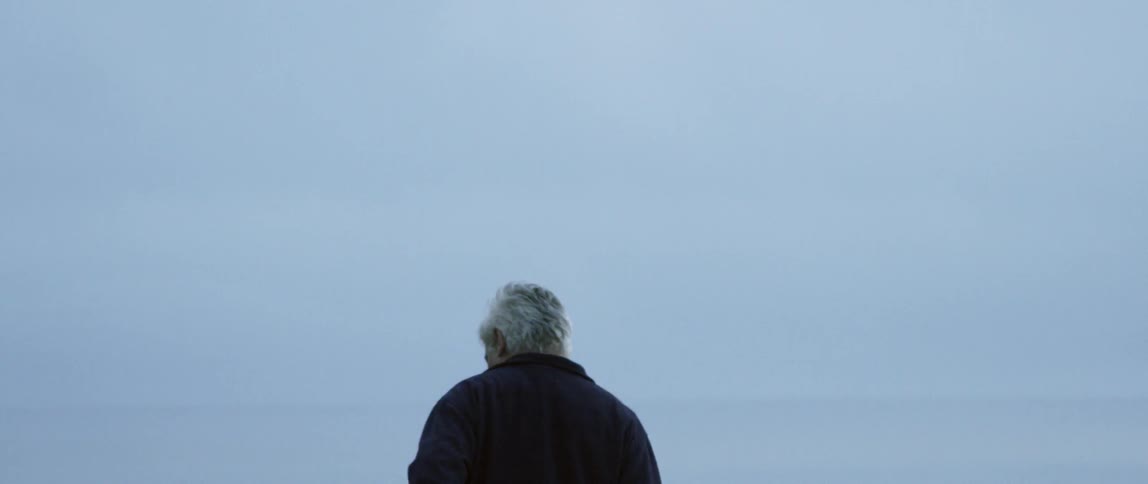 Elderly man stands alone outside