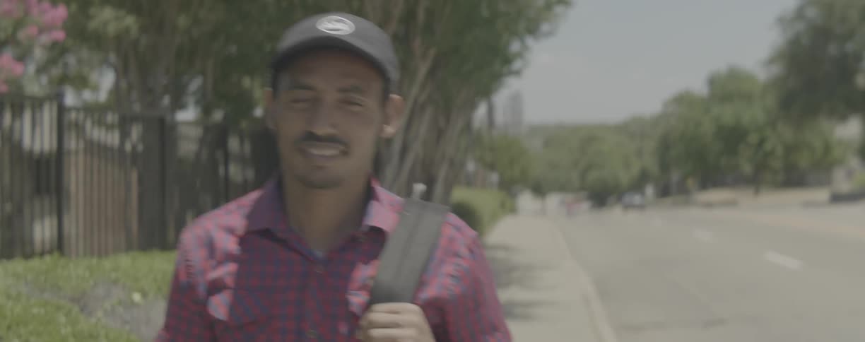 Man with backpack walks along highway