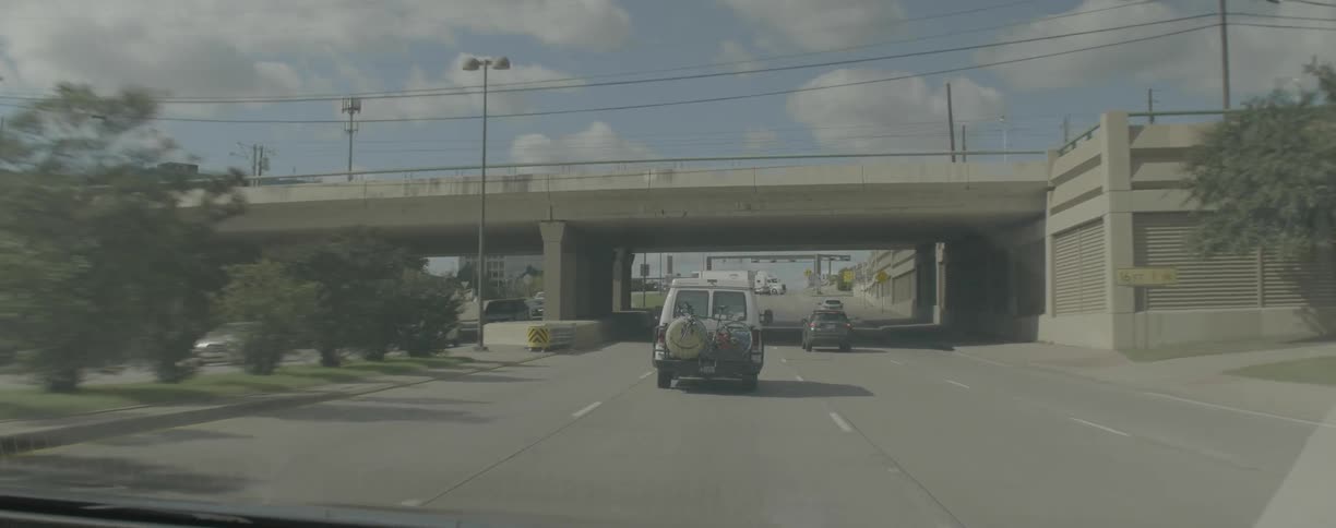 Cars are traveling on freeway on cloudy day