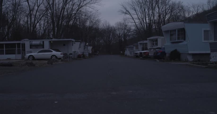 A view of the road in between two rows of trailers on a dreary winter day