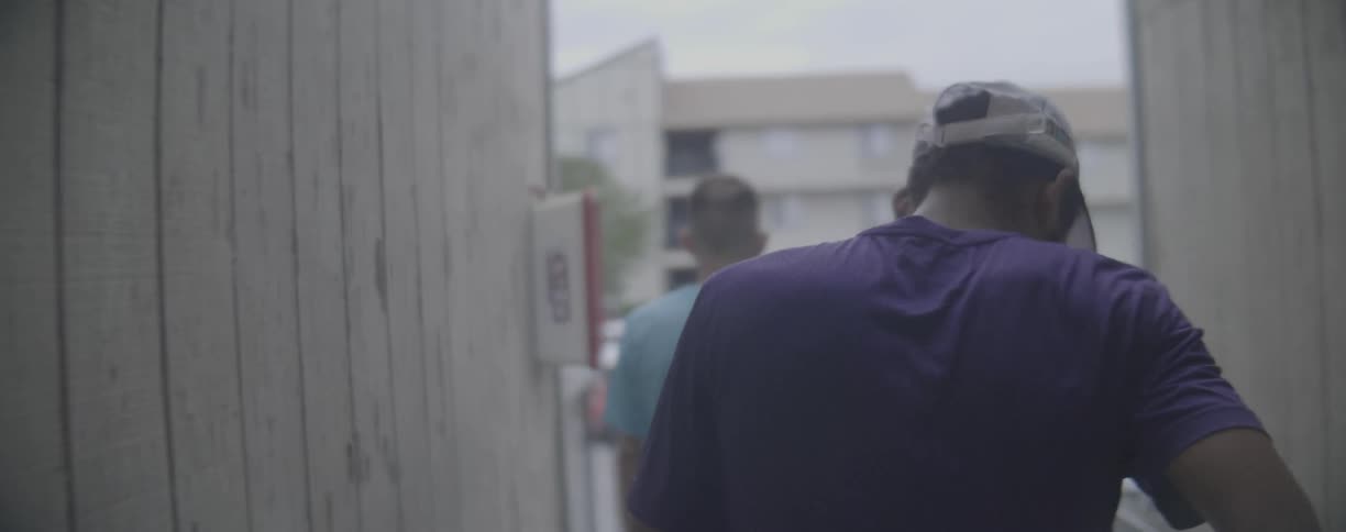 Two men walk between two buildings