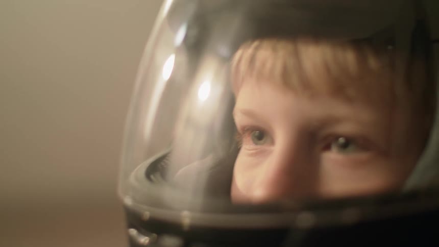 A young boy wears a helmet