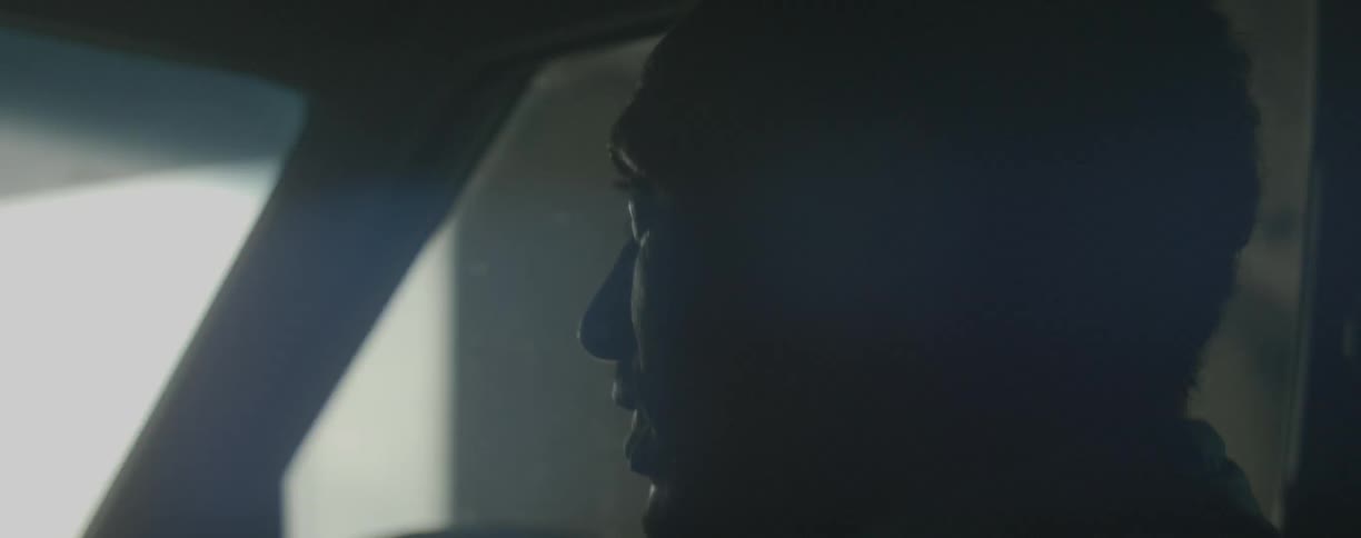 Man smiles and talks while riding in a car