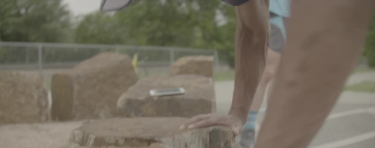 A man leans forward as he works his legs during an outdoor exercise