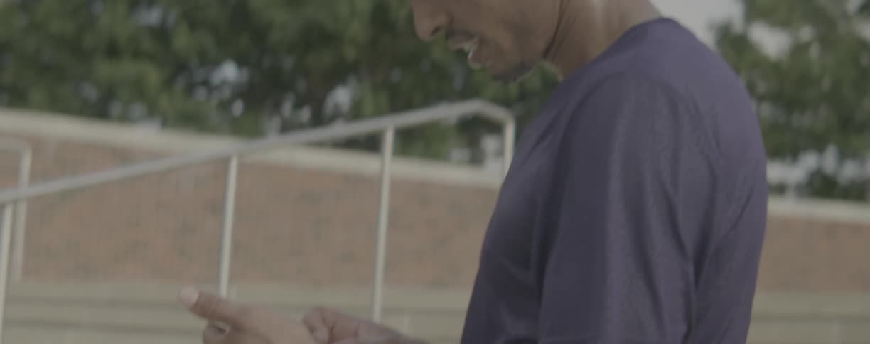 Man scrolls on his cellphone as he stands near the steps