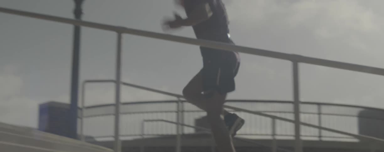 A man hops up city steps on one leg