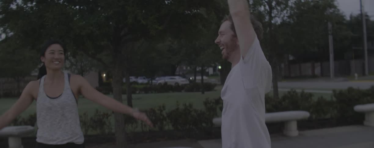 Man laughs as he stretches his arms over his head