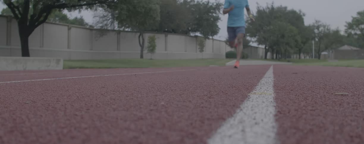 A man jogs on an outdoor track
