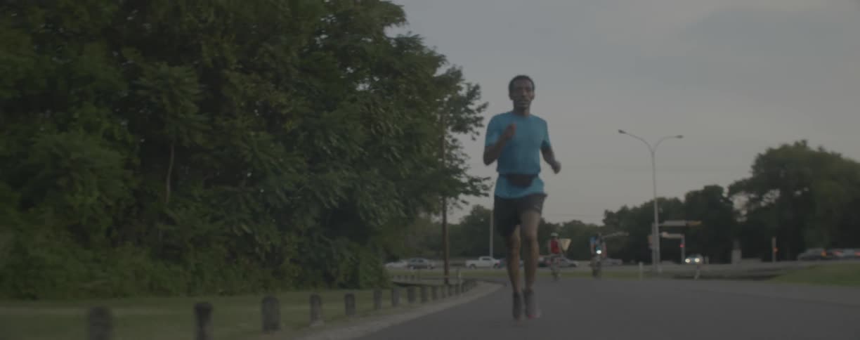 Man runs down the road as bicyclists approach