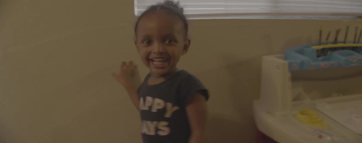 A young girl runs and plays at home