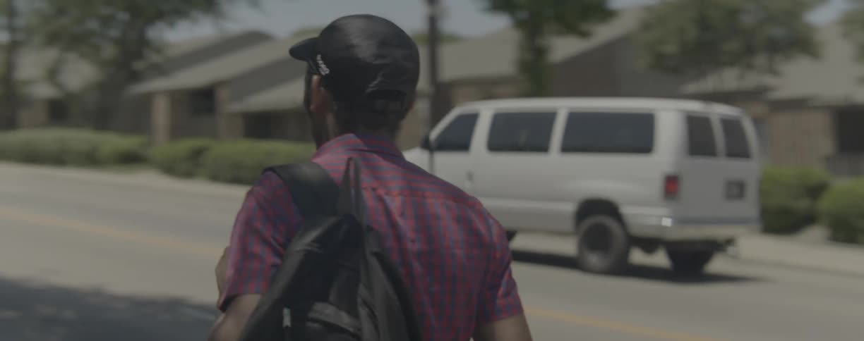 Man walks down the street a s a van drives by