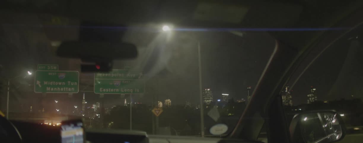 A car is driven on a city highway at night