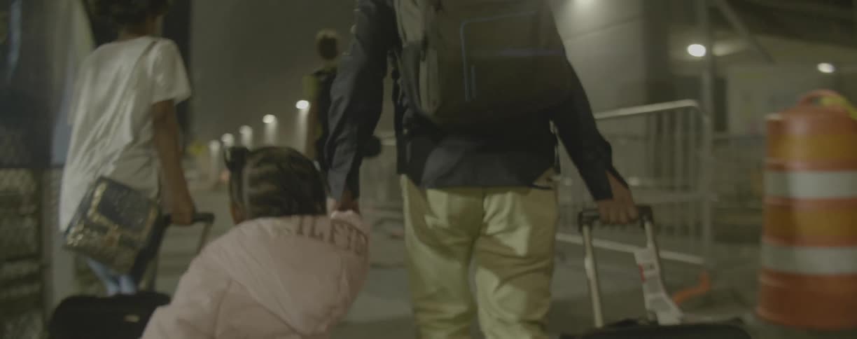 Woman and toddler walk hand in hand at the train station