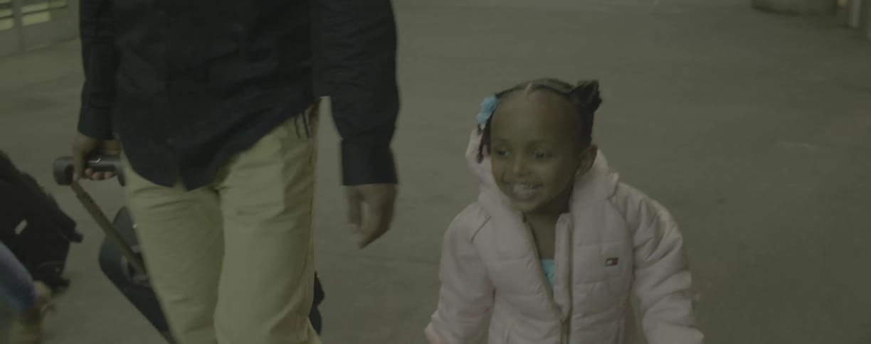 A young girl smiles while walking in an airport