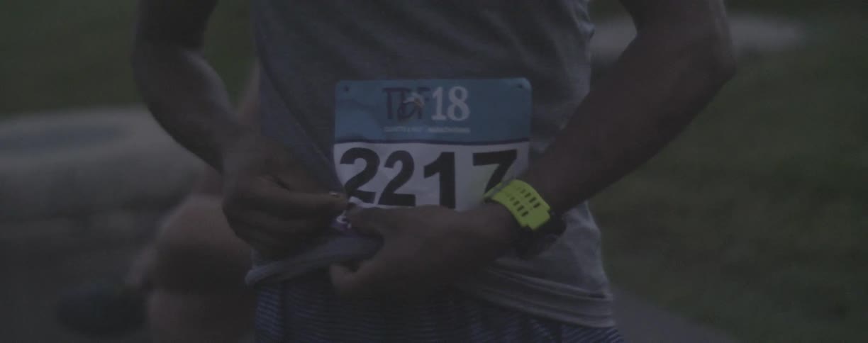 A runner pins a number to their shirt