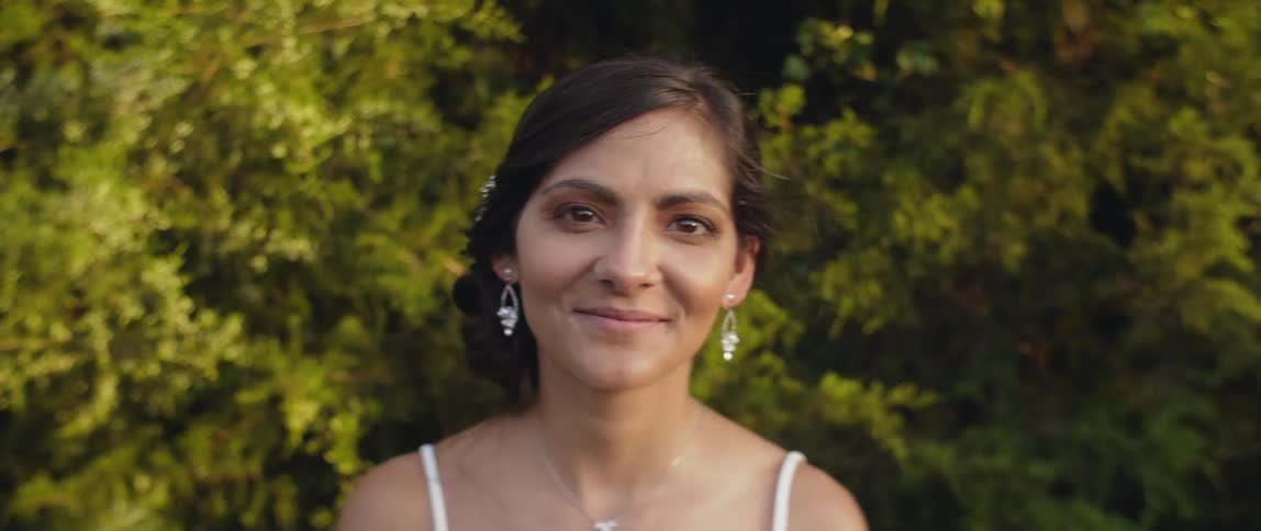 Bride is standing outside and smiling on sunny day