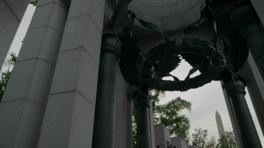 Metal wreaths and eagles decorate the columns of a memorial