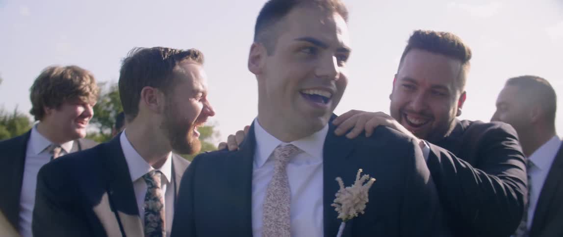 Groomsmen congratulating the groom outdoor on sunny day