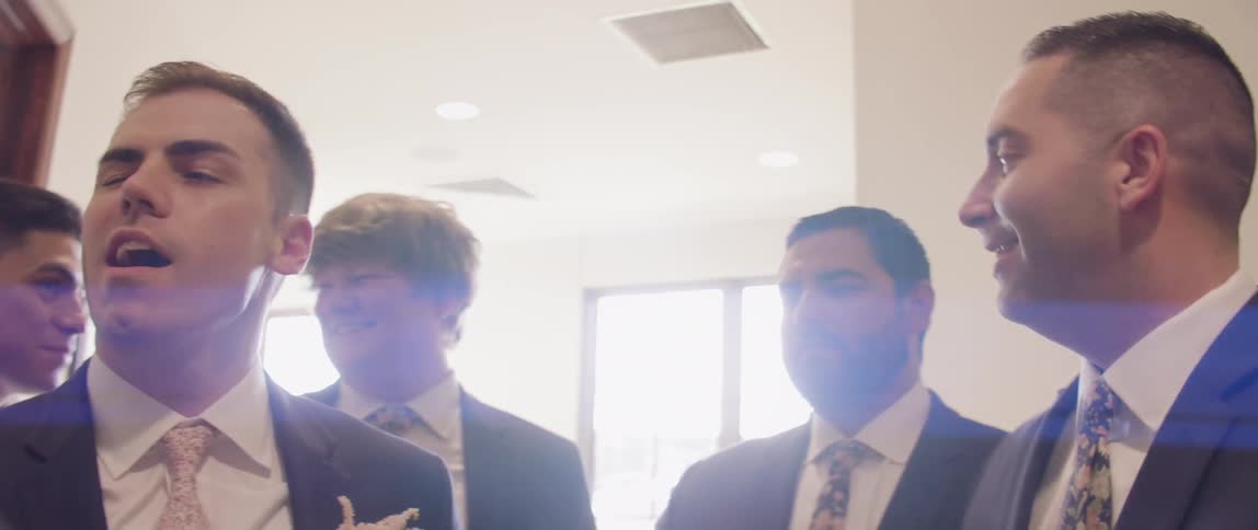 A groomsmen play punches the groom