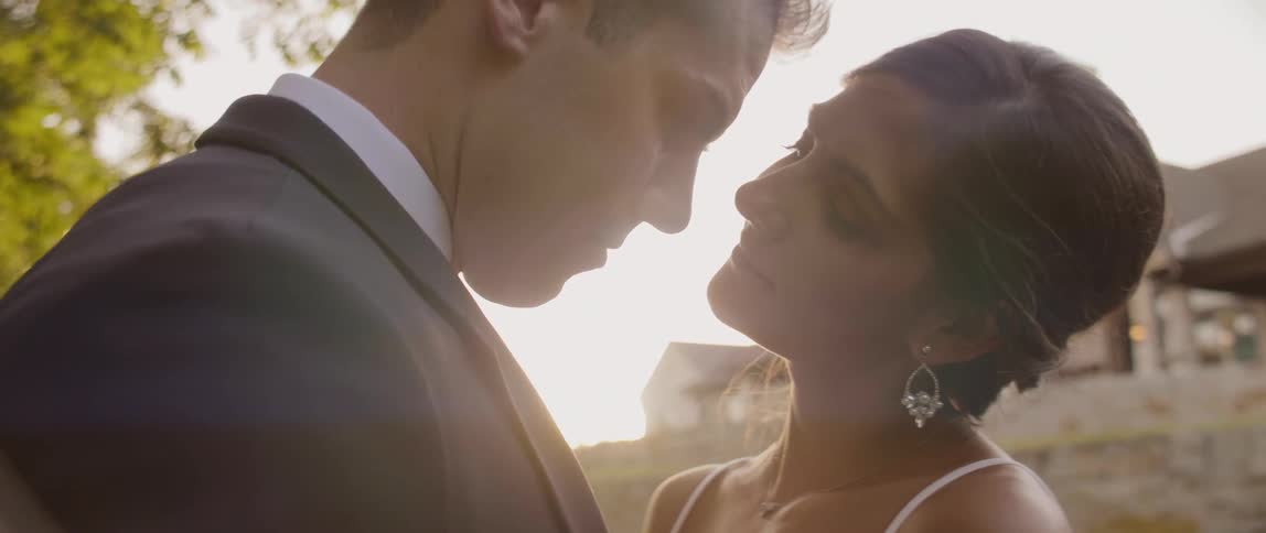A bride and groom gaze lovingly at each other at sunset
