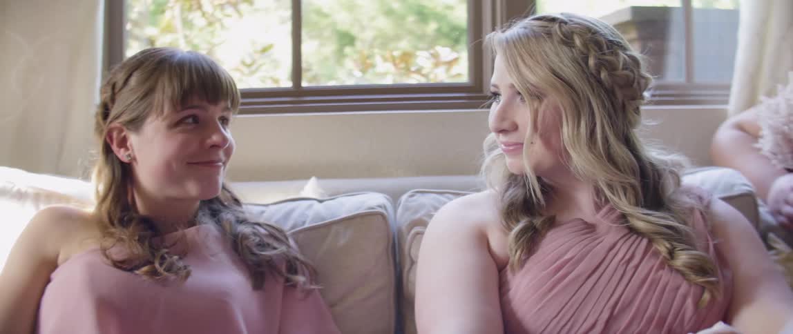Bridesmaids talk while sitting on a couch