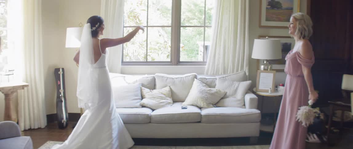 Bride and friend dance in living room