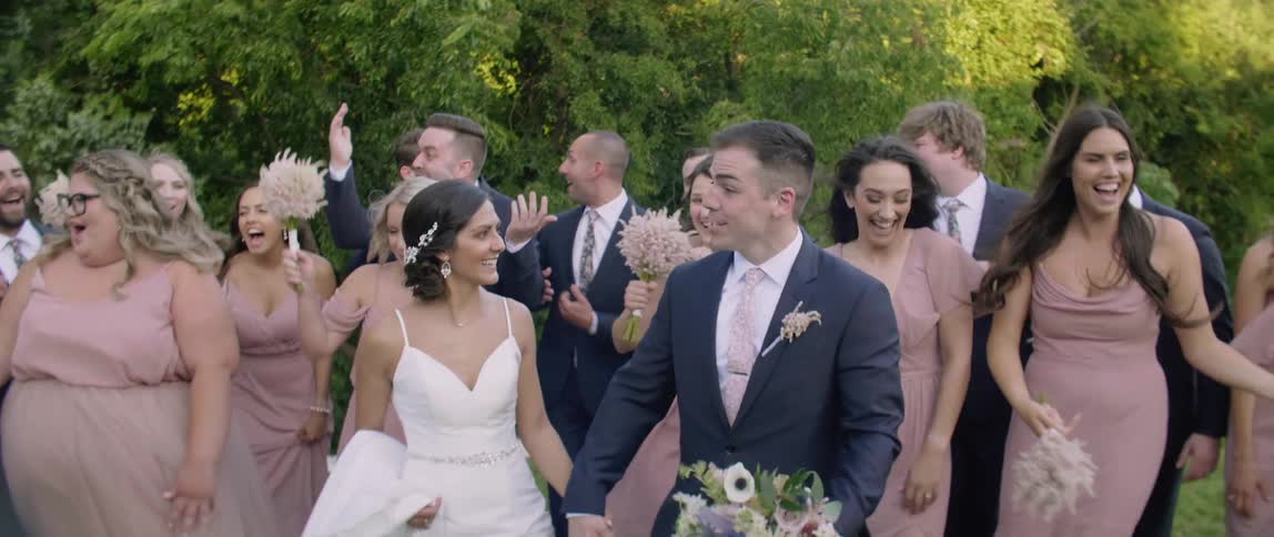 A bridal party smiles and celebrates outside