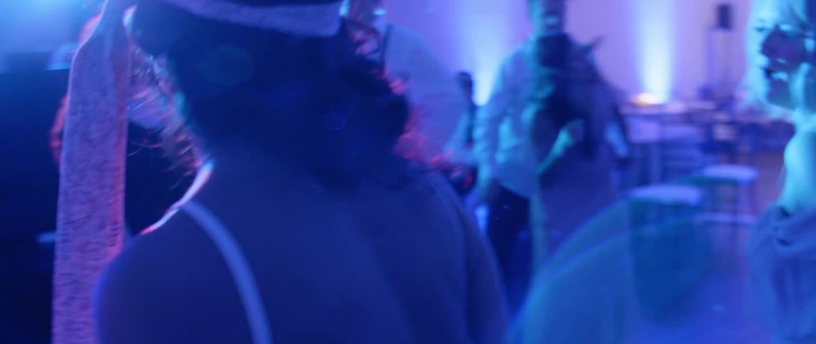 A bride dances with wedding guests at her reception
