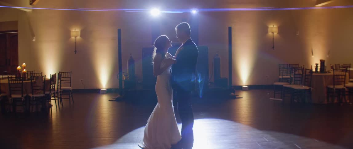 Bride and groom dance in empty ballroom